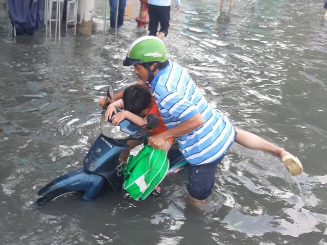 Nước ngập lút bánh xe máy vì vỡ bờ bao, người Sài Gòn “bơi” trên đường ngày đầu tuần